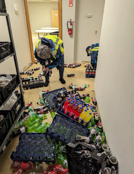 Volunteers cleaning up a spilled soda delivery inside the current facility