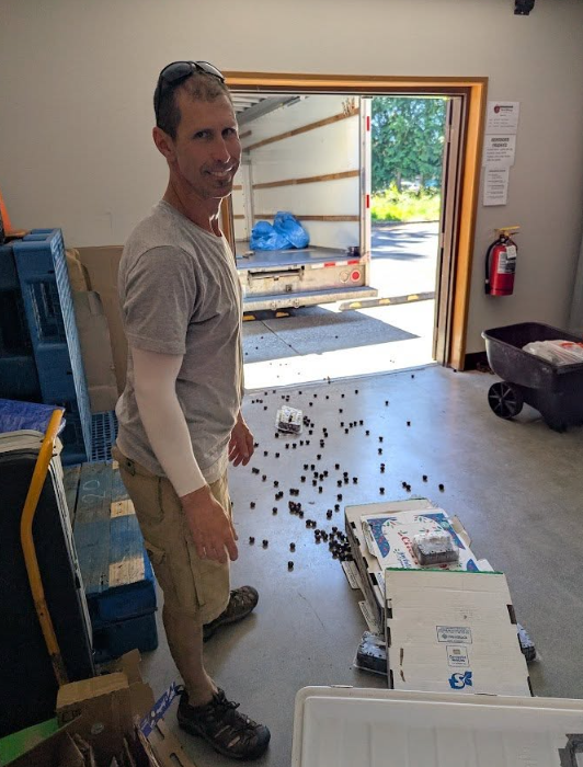 Volunteer unloading food from a truck into the current facility