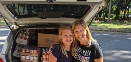 Volunteers with a vehicle loaded with donated food