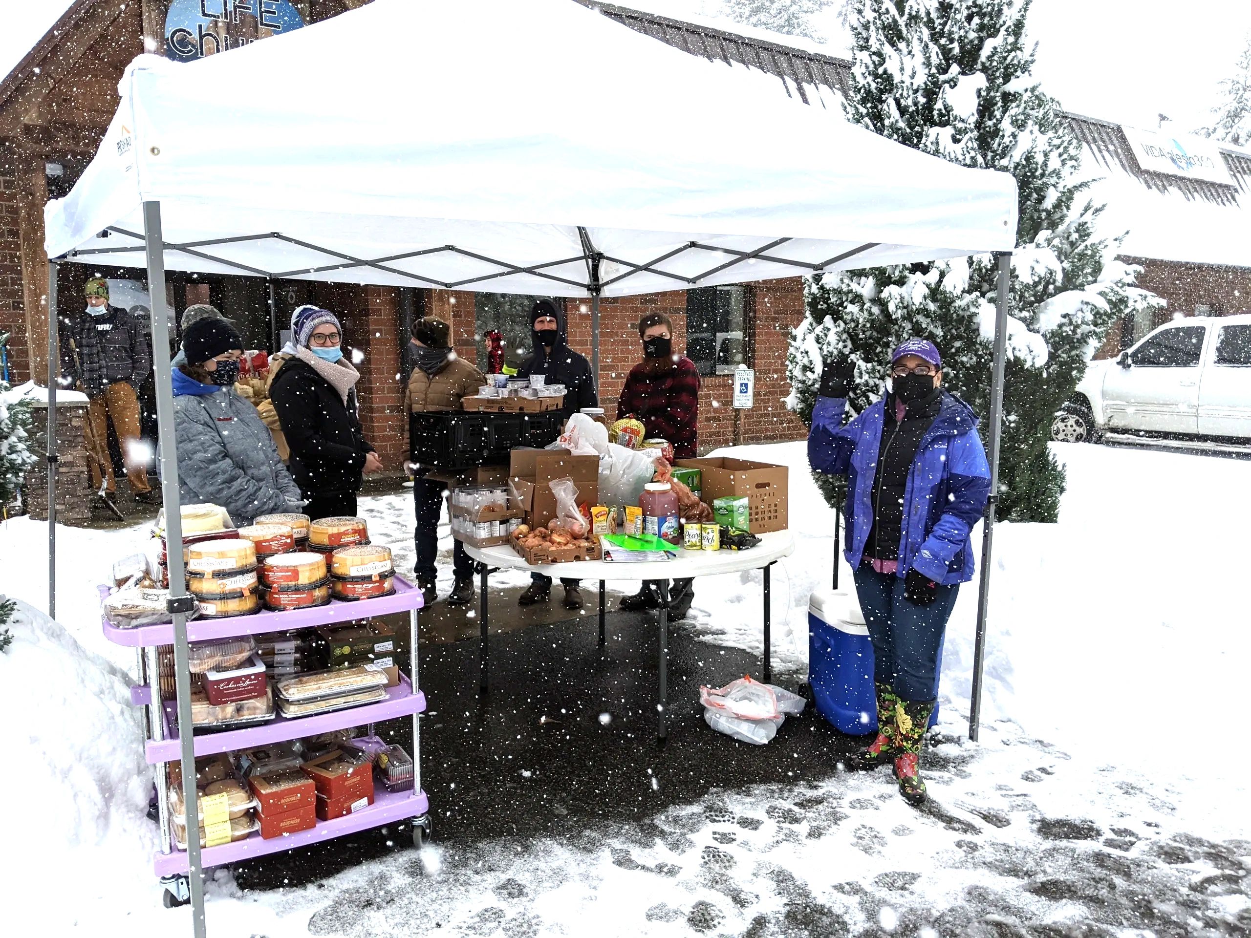Salt of the Earth volunteers serving food in the snow outside LIFEchurch360 in Arlington, showing dedication in all weather