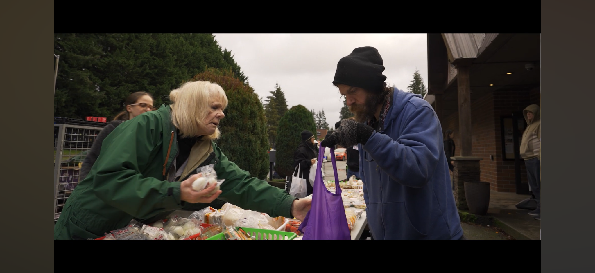 Salt of the Earth volunteer serving a community member during a food distribution